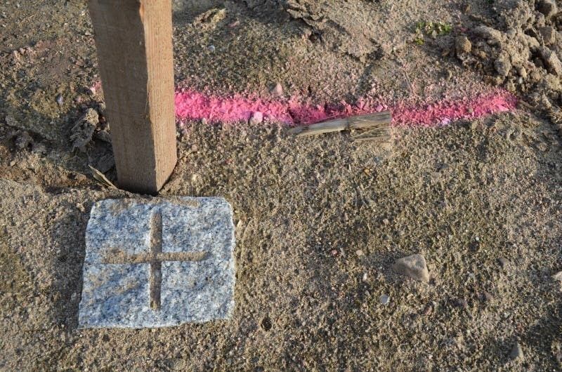 Ground markings and a wooden stake indicating a surveyed property boundary